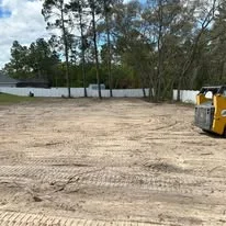 Excavated site with graded soil and yellow heavy equipment machinery