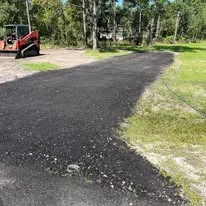 Newly graded and paved driveway with proper slope and clean grass edging