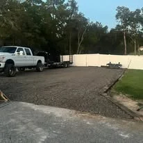Excavated driveway site with graded dirt base and white pickup truck on prepared ground