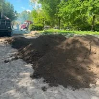 Excavated residential lot with stockpiled topsoil and heavy equipment on-site