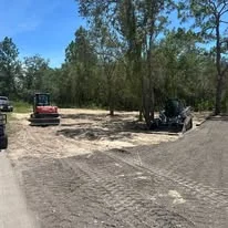 Excavated residential lot with heavy equipment and cleared earth material