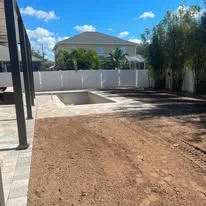 Excavated residential lot with compacted soil base and concrete pad visible